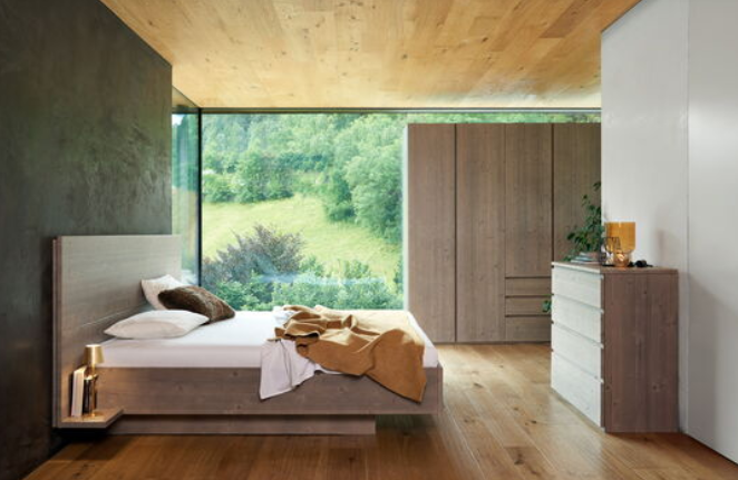 Massivholzbett New York in einem modernen Schlafzimmer mit Holzboden und großem Fenster